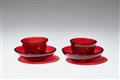 A pair of ruby glass tea bowls and saucers - image-1
