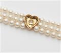 A cultured pearl necklace with an 18k gold heart set with a diamond solitaire. - image-3