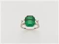 A Columbian platinum emerald and diamond three stone ring. - image-1