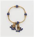 An archeological revival 18k gold and lapis lazuli bangle with tassels. - image-1