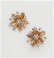 A pair of 14k gold and diamond snowflake clip earrings. - image-1