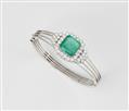 A German 14k white gold diamond and natural emerald bangle. - image-1