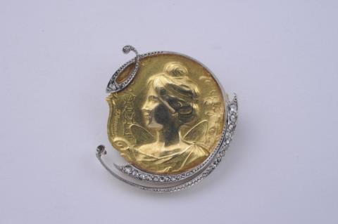Felix Rasumny - An 18k gold and platinum Art Nouveau relief medallion brooch with rose diamonds.