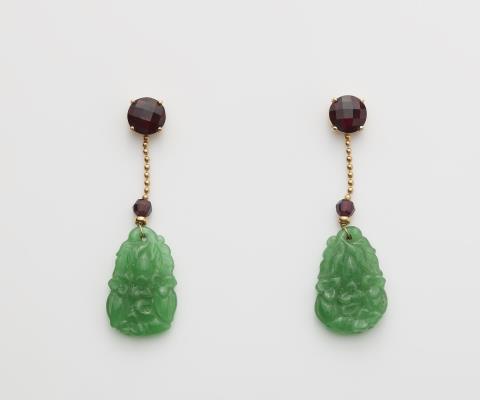 Jeweller Freisberg - A pair of German 18k gold garrnet and carved Burmese jade earrings.